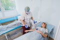 Nurse attaching intravenous tube to patient`s hand in hospital bed Royalty Free Stock Photo