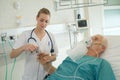 Nurse attaching pulse monitor to elderly patient