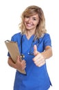 Nurse with blond hair and file showing thumb