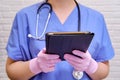 A nurse in a blue uniform holds a tablet during quarantine . A doctor with a stethoscope remotely helps via the Internet