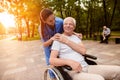 The nurse laid her hand on the old man`s shoulder, who was sitting in a wheelchair and looking at him Royalty Free Stock Photo
