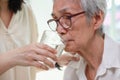 Nurse or caregiver gives drinking fresh water to senior woman in hospital or nursing home,Thirsty elderly grandmother suffering