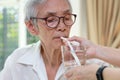 Nurse or caregiver taking care of disabled senior grandmother gives drinking water,feeding water using a straw to prevent choking