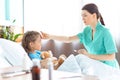 Nurse checking temperature of sick little girl in hospital bed Royalty Free Stock Photo