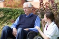 Nurse Comforting Senior Man In Wheelchair