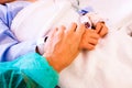 A nurse comforts a sick child by holding her hand