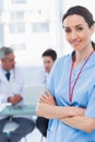 Nurse crossing arms with her colleagues behind Royalty Free Stock Photo