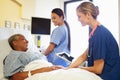 Nurse With Digital Tablet Talks To Woman In Hospital Bed Royalty Free Stock Photo