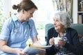 Nurse Discussing Medical Notes With Senior Woman At Home Royalty Free Stock Photo