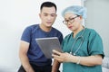 Nurse discussing x-ray on tablet with patient