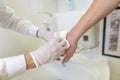 Nurse disinfects a patients hand at a sink