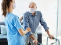 nurse doctor senior care caregiver help walker assistence retirement home nursing man virus mask corona Royalty Free Stock Photo