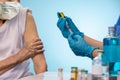 Nurse doing vaccine injection to senior woman