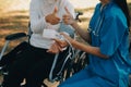 nurse with elderly man in wheelchair at park Royalty Free Stock Photo