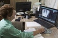 A nurse examines a radiograph of a patient on a monitor