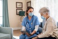 Nurse explaining therapy to senior woman at home visit Royalty Free Stock Photo