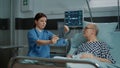 Nurse explaining xray test results to patient in hospital ward