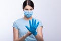 Nurse with face mask wear and checking protective gloves