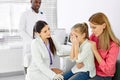 nurse female doctor general practitioner talks and amuses child before medical examination