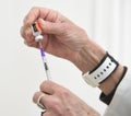 A nurse fills a syringe with a Pfizer vaccine