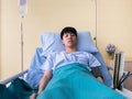 Nurse give Asian influenza virus patient man saline intravenous fluid and measure blood pressure while he lying down on hospital