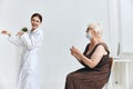 A nurse giving an injection to an elderly woman with a syringe vaccine passport Royalty Free Stock Photo