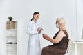 Nurse giving injection to elderly woman large syringe vaccine passport Royalty Free Stock Photo