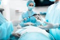 Nurse giving laparoscopic instrument to doctor during surgical operation