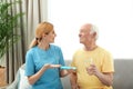 Nurse giving medication to elderly man indoors Royalty Free Stock Photo