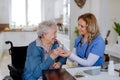 Nurse giving medicine to senior woman at her home. Royalty Free Stock Photo