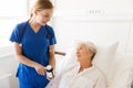 Nurse giving medicine to senior woman at hospital Royalty Free Stock Photo