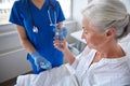 Nurse giving medicine to senior woman at hospital Royalty Free Stock Photo