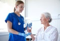 Nurse giving medicine to senior woman at hospital Royalty Free Stock Photo