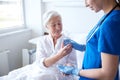 Nurse giving medicine to senior woman at hospital Royalty Free Stock Photo