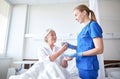 Nurse giving medicine to senior woman at hospital Royalty Free Stock Photo