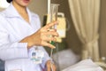 Nurse giving patient water using glass syringe to irrigate nasogastric tube in hospital