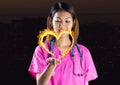 nurse with hand spread of with heart fire icon over in front of the city at night.