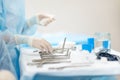 A nurse hands surgical instruments to a doctor during maxillofacial surgery operation. Sterile medical tools