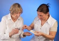 Nurse is helping elderly woman with handing out pills