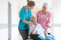 Nurse helping elderly woman in wheelchair