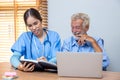 Nurse helping patient for reading note book. woman helping senior man read note book Royalty Free Stock Photo