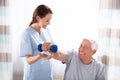 Nurse Helping Senior Man With Dumbbell Exercise Royalty Free Stock Photo