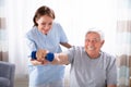 Nurse Helping Senior Man With Dumbbell Exercise Royalty Free Stock Photo