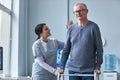 Nurse helping senior man using mobility walker in retirement home Royalty Free Stock Photo