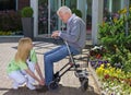 Nurse Helping Senior Man with Walker to Tie Shoes Royalty Free Stock Photo