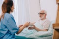 Nurse helping senior patient in bed to hold Royalty Free Stock Photo