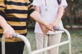 Nurse helping senior woman hands holding walker trying to walking at outdoor,Care nursing home concept,Physical therapy Royalty Free Stock Photo