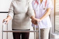 Nurse helping senior woman hand holding walker trying to walk,Care nursing home concept Royalty Free Stock Photo