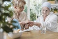 Nurse helping sick elderly woman with cancer during treatment at home