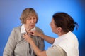 Nurse helps a senior woman with dressing